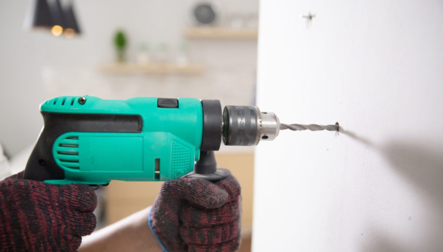 hands with gloves using electric drill